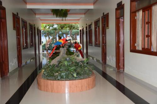 a statue of a bird on a plant in a hallway at Amazonia Hotel in Cobija