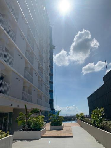 a large apartment building with the ocean in the background at Hola! Condotel @ Inspiria Davao in Davao City
