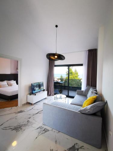 a large living room with a couch and a tv at Pine Resort in Polychrono