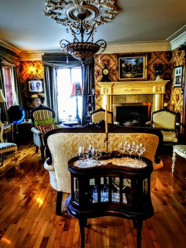 a living room with a fireplace and a table with wine glasses at Auberge J.A Moisan in Quebec City