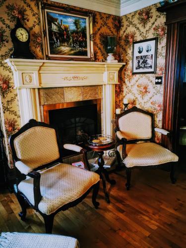 a living room with two chairs and a fireplace at Auberge J.A Moisan in Quebec City