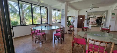 une chambre avec deux tables, des chaises et des fenêtres dans l'établissement Hotel Taboga Eco Boutique & Spa Costa Esmeralda, à Monte Gordo