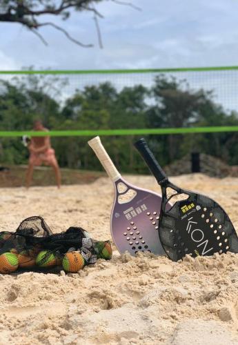 two golf clubs and balls in the sand on a beach at Pousada da Pedra Rifaina in Rifaina