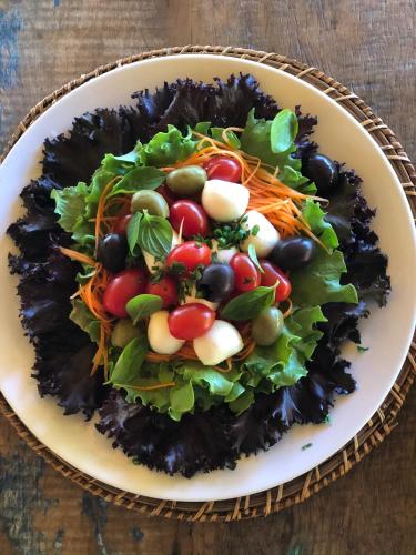 a plate of salad with vegetables on a table at Pousada da Pedra Rifaina in Rifaina