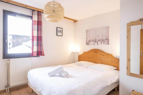 une chambre avec un lit blanc et une fenêtre dans l'établissement Appartement Les lutins - incredible view of Mont Blanc, à Chamonix-Mont-Blanc