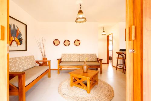 a living room with two couches and a table at UNKUÉ POUSADA FLATS in Jericoacoara