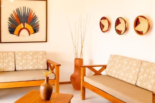 a living room with two chairs and a table at UNKUÉ POUSADA FLATS in Jericoacoara