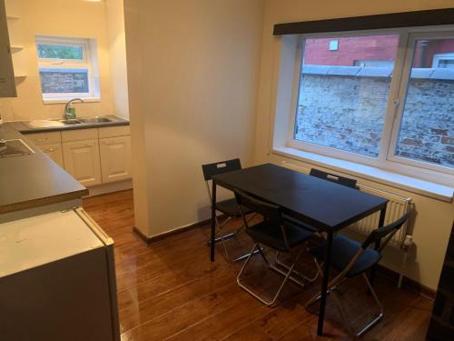 a kitchen with a table and chairs in a room at 3/4 Bedroom House in Manchester