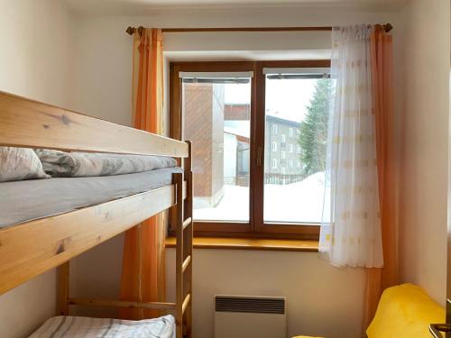 una stanza con due letti a castello e una finestra di Horský apartmán ROKY - Krkonoše a Rokytnice nad Jizerou