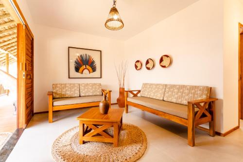 a living room with two couches and a table at UNKUÉ POUSADA FLATS in Jericoacoara