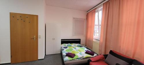 1 dormitorio con cama, sofá y ventana en Gästewohnung Kristall 3, en Salzwedel