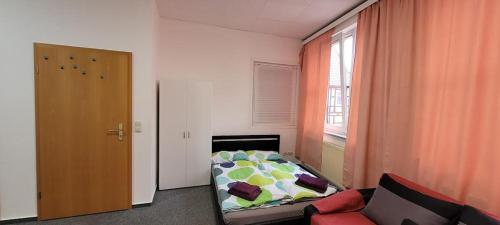 a bedroom with a bed and a couch and a window at Gästewohnung Kristall 3 in Salzwedel