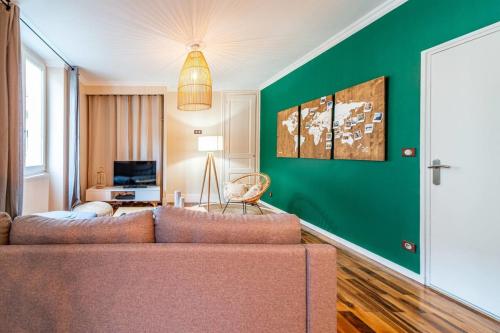 a living room with a couch and a green wall at Les Antiquaires #CQ in Grenoble