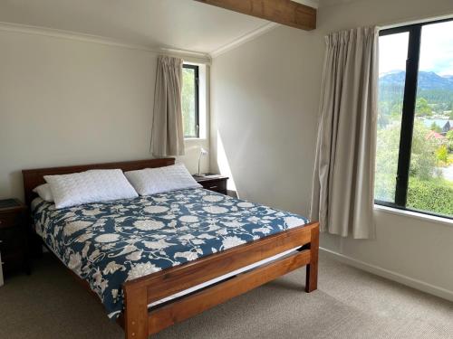 Un dormitorio con una cama y una ventana grande. en 51 St James Avenue, en Hanmer Springs