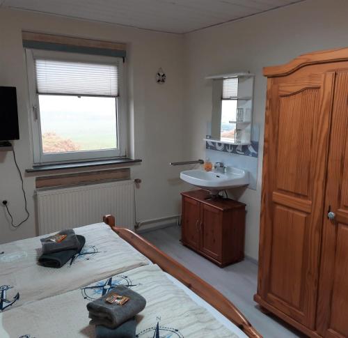 a bedroom with two twin beds and a sink at Gästehaus Mia in Norddeich