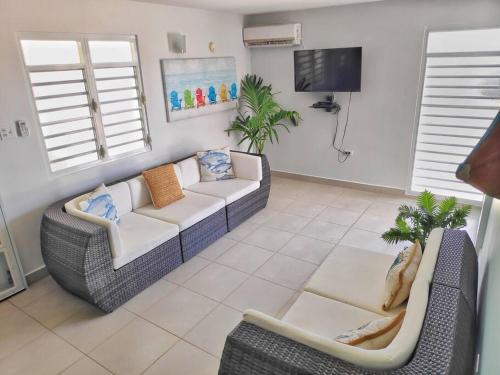 a living room with two couches and a tv at Casa Mar Azul cerca de la playa de Flamenco in Culebra