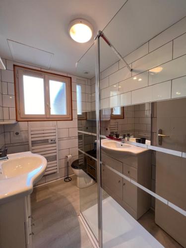 a bathroom with two sinks and a glass shower at T2 ensoleillé. Terrasse et vaste jardin commun in Cauterets