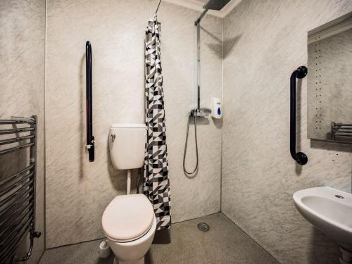 a bathroom with a toilet and a sink and a shower at Epsilon Hotel in London