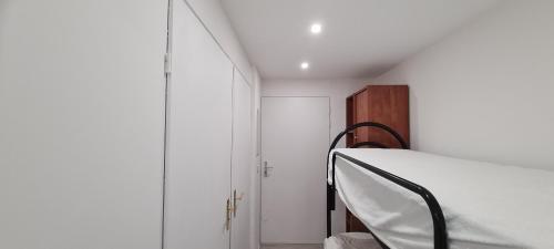 une chambre avec un lit blanc et une armoire en bois dans l'établissement le calypso, à Saint-Aygulf