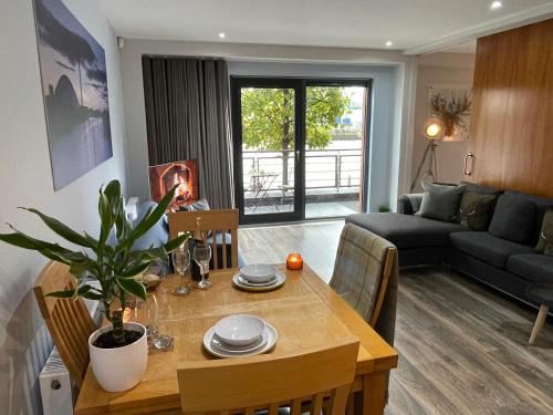 ein Wohnzimmer mit einem Tisch und einem Sofa in der Unterkunft Riverside West End Apartment in Glasgow