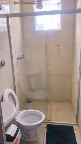 a bathroom with a toilet and a glass shower at Hostel da Moda in Passos