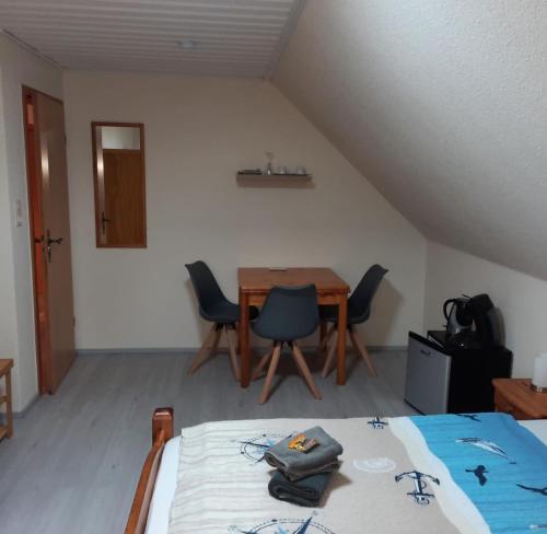 een kamer met een bed en een tafel en stoelen bij Gästehaus Mia in Norddeich