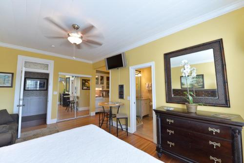 a bedroom with a bed and a dresser with a mirror at Old Colorado Inn in Stuart