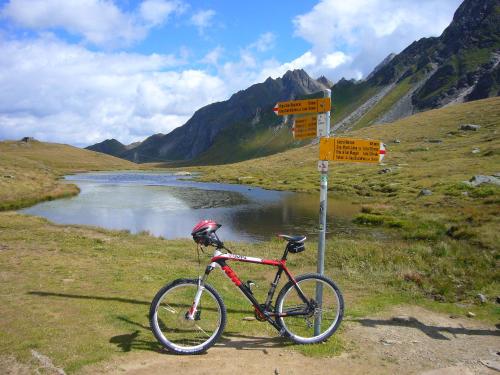 a bike parked next to a sign next to a river at Kinghouse in Domodossola