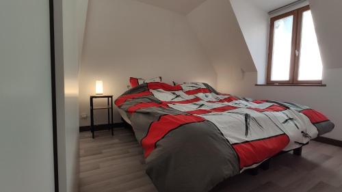 a large bed in a room with a window at jolie maison face à la dordogne in La Bourboule