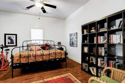 um quarto com uma cama e uma estante de livros em Artsy Heights House: Walk To Food-Bars-Shops-Trails, Kids & Pet Friendly em Houston