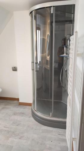 - une douche en verre dans une chambre avec une table dans l'établissement maison face à la dordogne avec terrasse, à La Bourboule