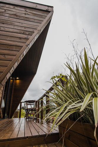a wooden deck with a chair and a table at Pousada Colina Verde in Garopaba