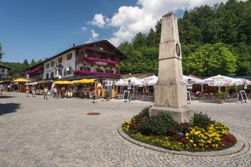 a monument in the middle of a square with flowers at Hotel Königssee in Schönau am Königssee