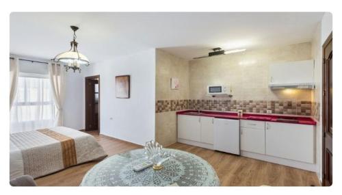 cocina con cama y mesa en una habitación en APARTAMENTO EN OLVERA CON GARAJE, en Olvera