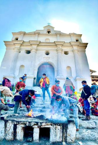 a group of people standing around a fire in front of a building at Hotel Museo Mayan Inn in Chichicastenango