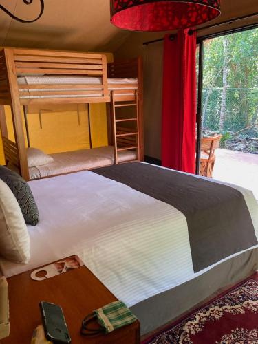 a bedroom with a bed and a bunk bed at Serenity Authentic Glamping Tulum in Xpu Ha