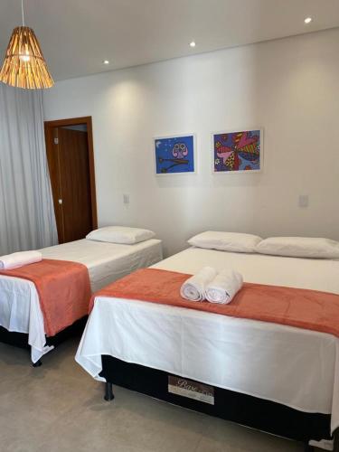 two beds in a hotel room at Casa Beija Flor in Porto Seguro