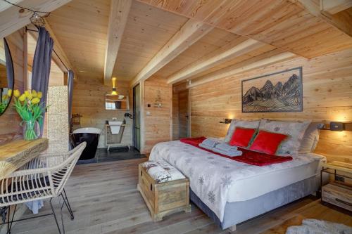 1 dormitorio con 1 cama en una cabaña de madera en Pod Lasem en Krynica Zdrój