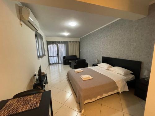 a bedroom with a bed and a living room at AVR Airport Deluxe Suites 4 in Markopoulo