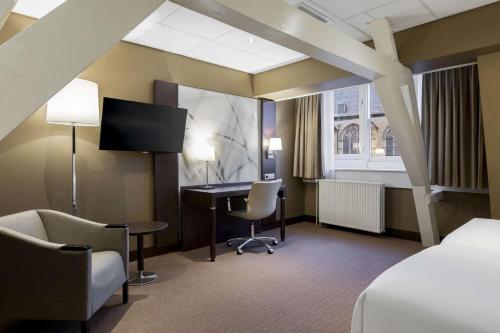 a hotel room with a bed and a desk and a computer at NH Centre Utrecht Hotel in Utrecht