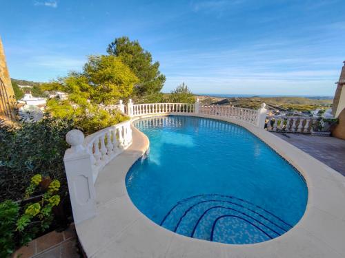 une piscine entourée d'une clôture blanche. dans l'établissement villa Anastasia, à Cumbre del Sol
