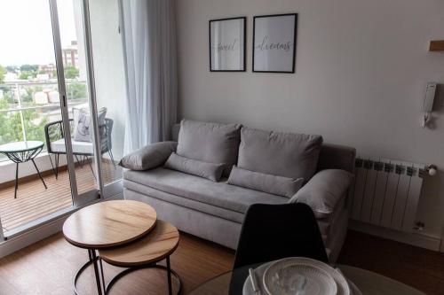 a living room with a couch and tables and a balcony at Sweet Dreams I in Junín