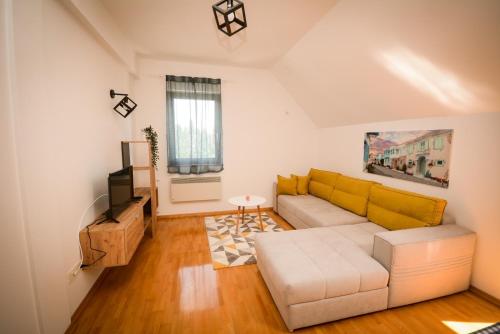 uma sala de estar com um sofá e uma televisão em Apartmani Vila Goč em Goc