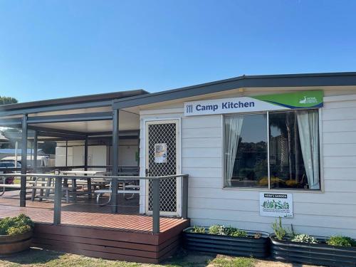 a building with a patio with a table in it at Victor Harbor Holiday Park in Victor Harbor
