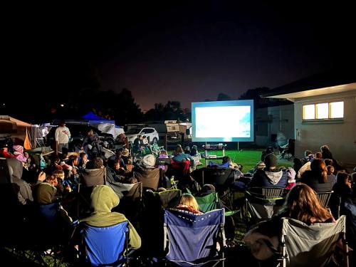 a crowd of people sitting in chairs watching a screen at Victor Harbor Holiday Park in Victor Harbor