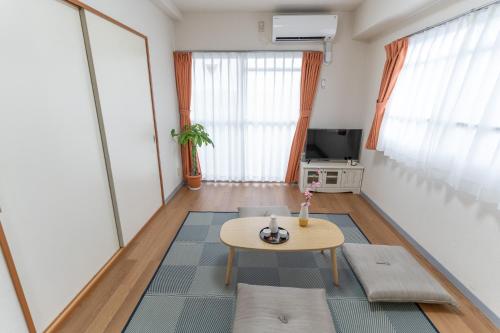 a living room with a table and a tv at stay's ジローズ浄心 501号 名古屋 民泊 駅近 in Noritake-Shinmachi