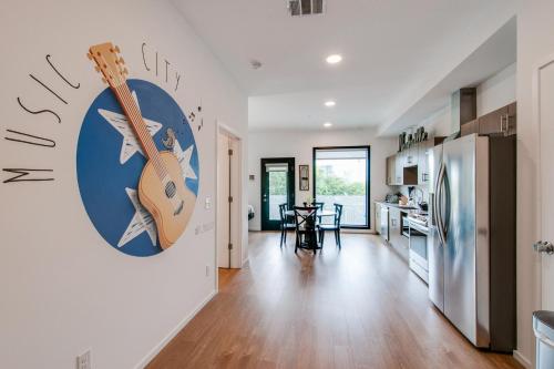 a kitchen and living room with a guitar on the wall at Illume 217 in Nashville