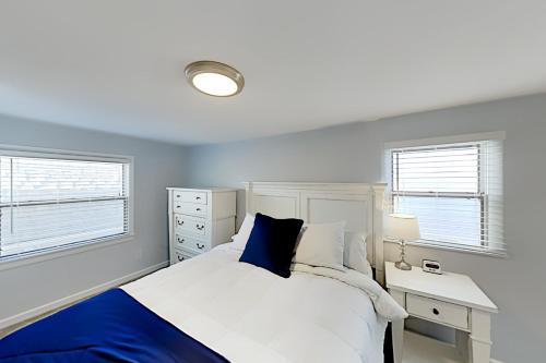 a bedroom with a bed and a desk and two windows at Sandyhill Sun in Ocean City