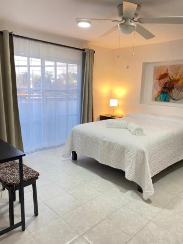 a bedroom with a bed and a ceiling fan at Departamento Colibrí in Cozumel