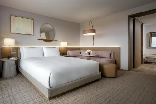 a bedroom with a large white bed and a couch at Fairmont Century Plaza Los Angeles at Beverly Hills in Los Angeles